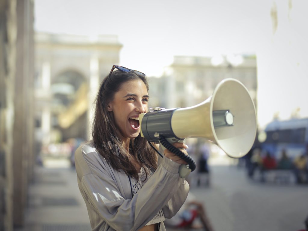 woman with megaphone, symbolising finding your brand voice (Little Bird Creative blog)