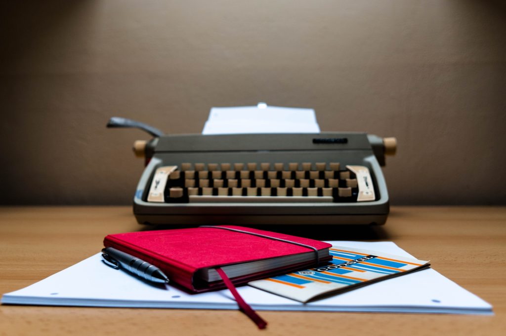 image of a typewriter and notebook, representing copywriting by Little Bird Creative