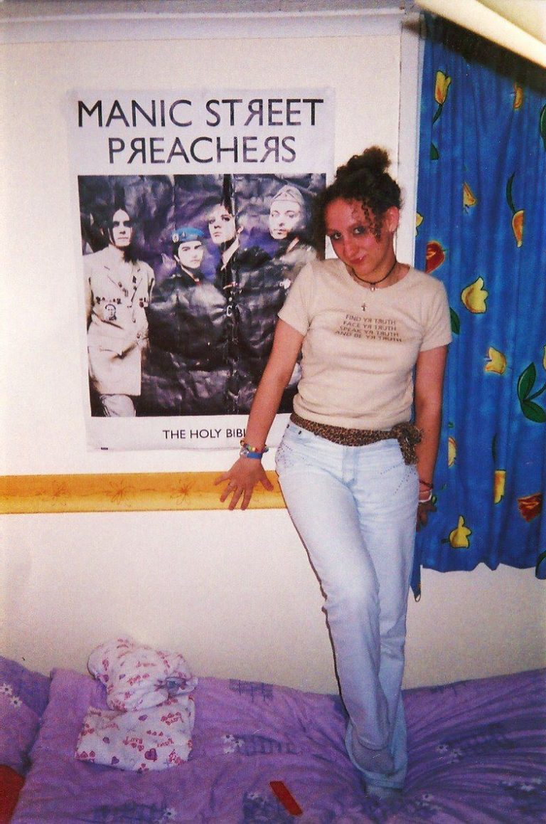 Little Bird Creative's Emma poses beside a Manic Street Preachers poster, 2003.