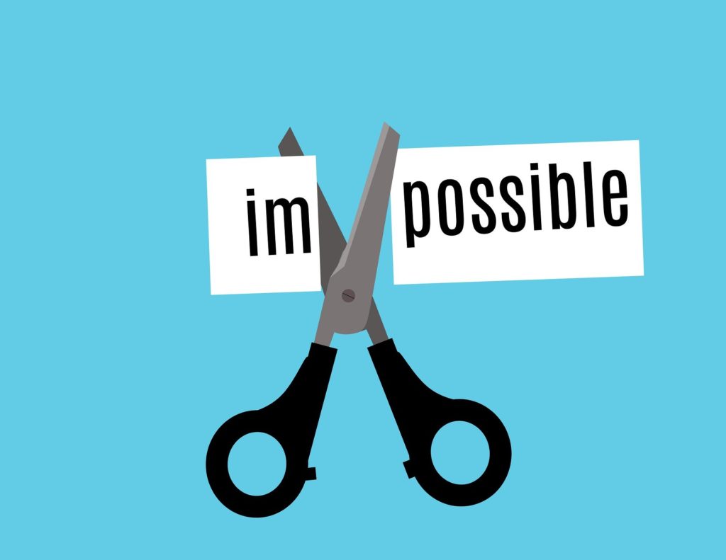 a drawing of a pair of scissors cutting through the word "impossible" to illustrate that we love a challenge