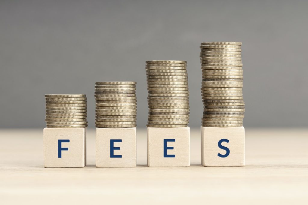The word "fees" with increasing piles of coins on top.