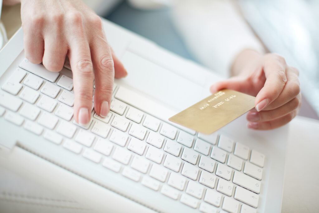 Stock photo of a hand holding a credit card to buy something online.