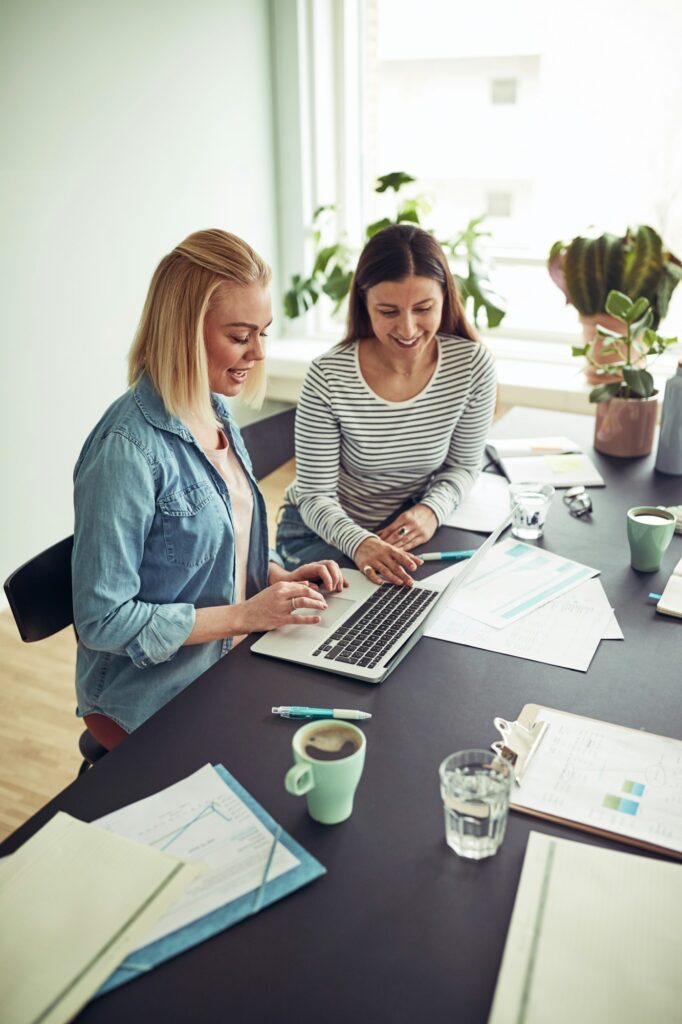 Women smiling as they work together - Little Bird Creative are a small business and will take the time to get to know you