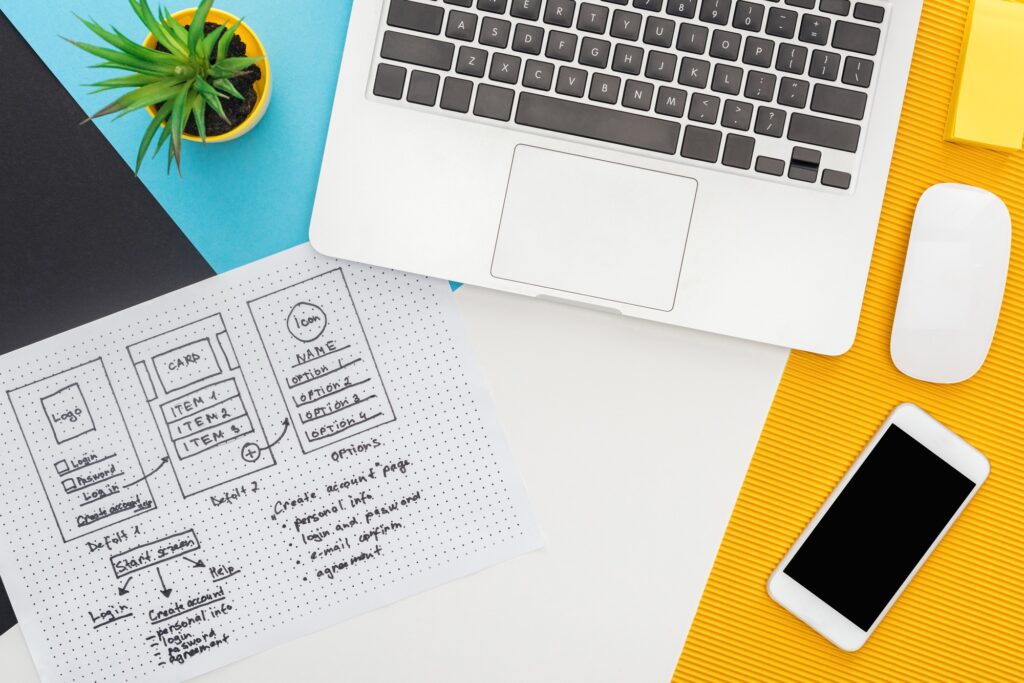 top view of website design template near laptop, computer mouse, smartphone, plant to illustrate how to build your own website
