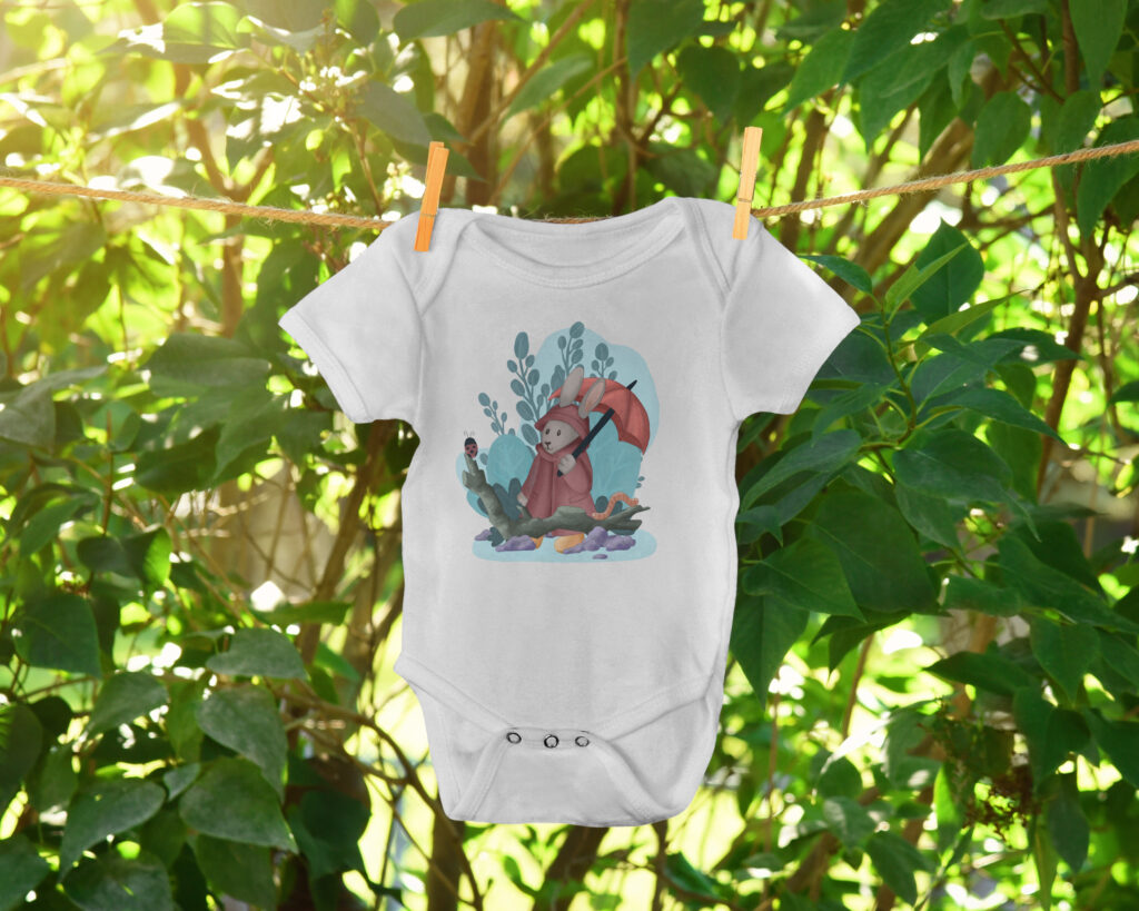 White baby vest with an illustration of a bunny with an umbrella, designed by Little Bird Creative and available to purchase in our online shop